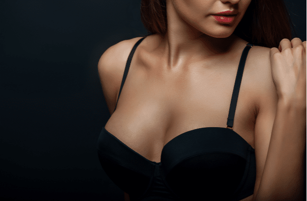 Close up of breast of attractive woman presenting her black bra. 0