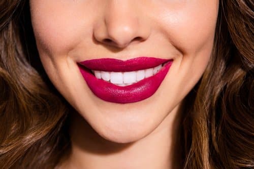 wavy haired lady with plump sensual red lips and bright smile