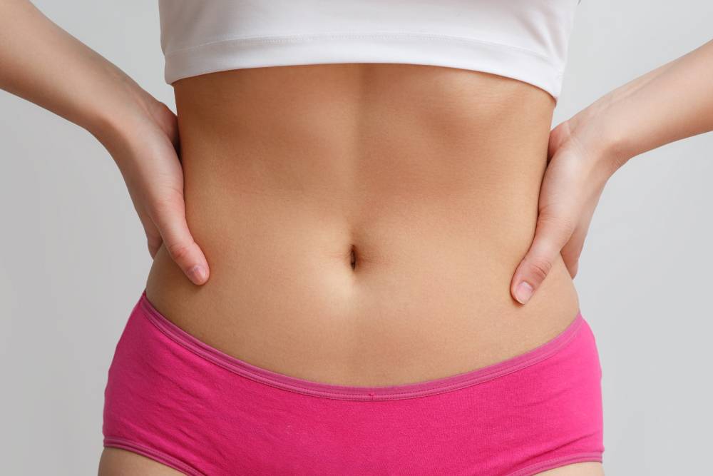 Woman’s midsection features a thin, toned tummy after her pregnancy thanks to abdominoplasty.
