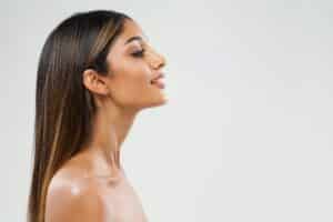 Side profile of woman with slim, defined chin and jawline from chin liposuction in Huntington Beach