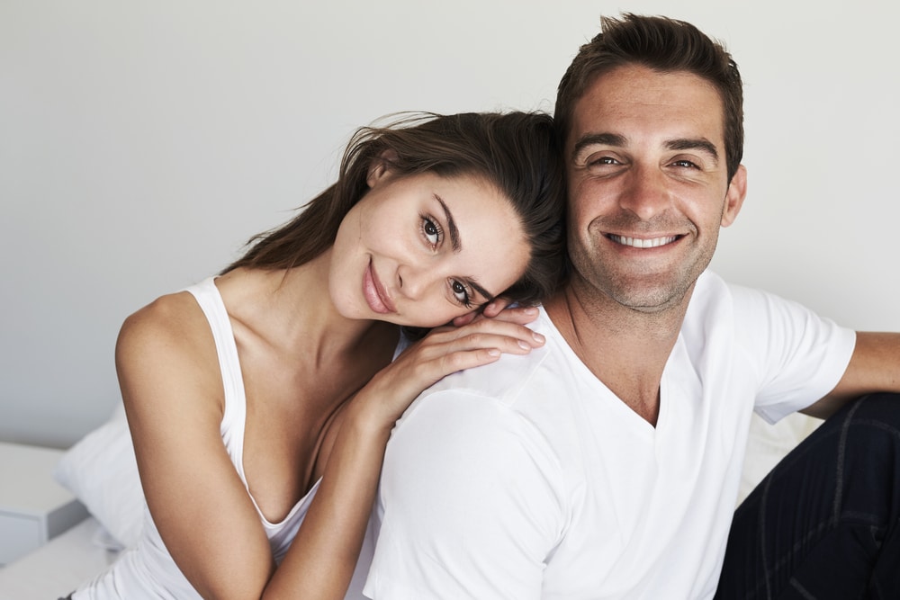 Woman with man in bedroom after labiaplasty in Huntington Beach, CA