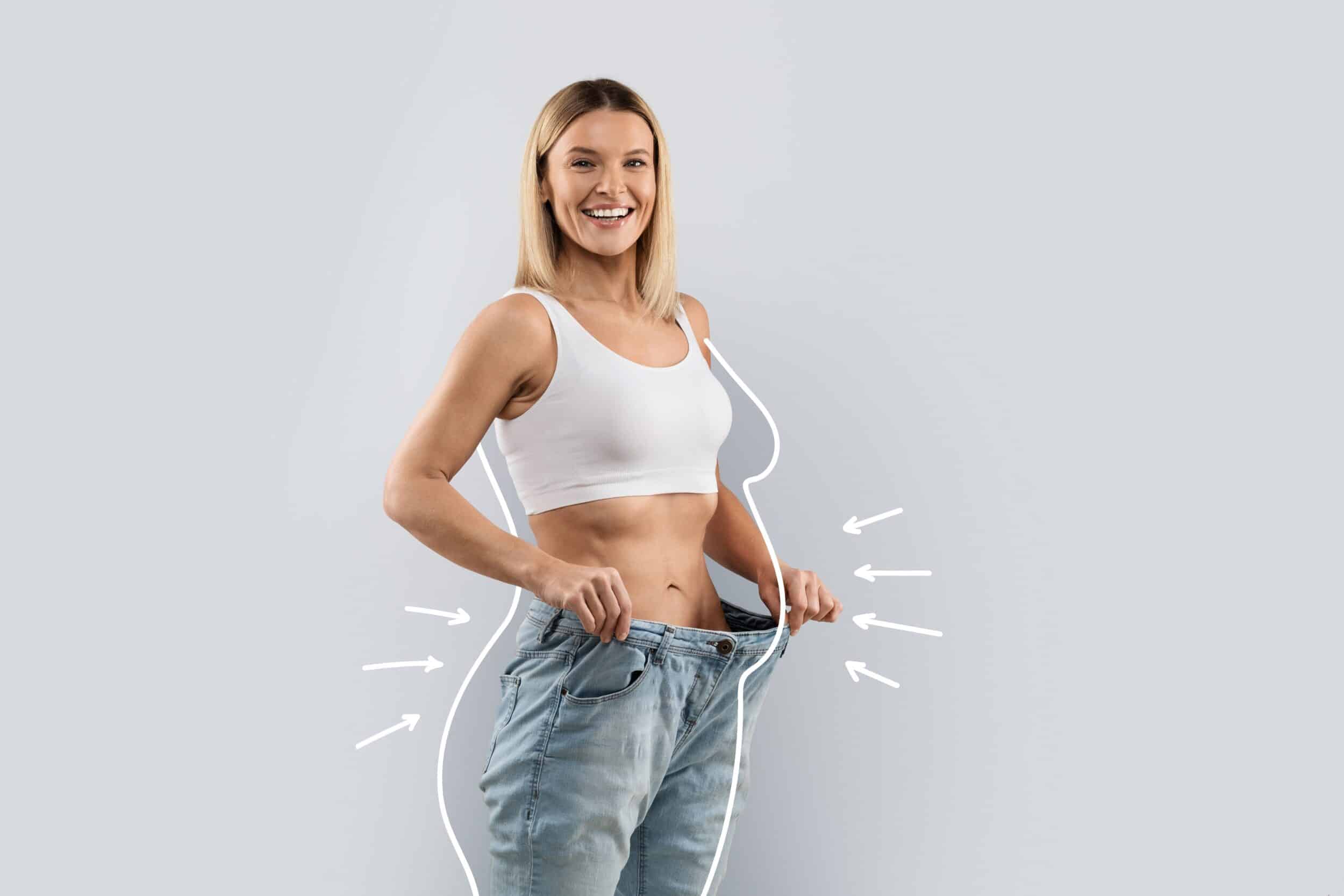 Woman smiling in baggy jeans to show post massive weight loss results in Huntington Beach