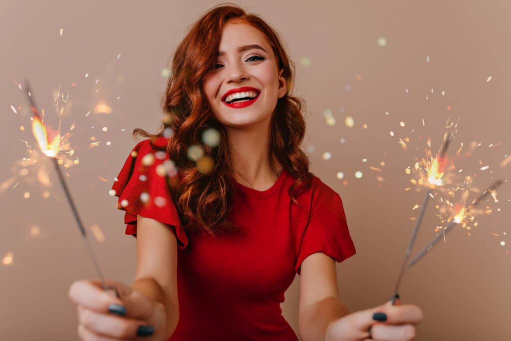 Smiling woman with sparklers, dressed for holiday party, after Dysport in Huntington Beach, CA